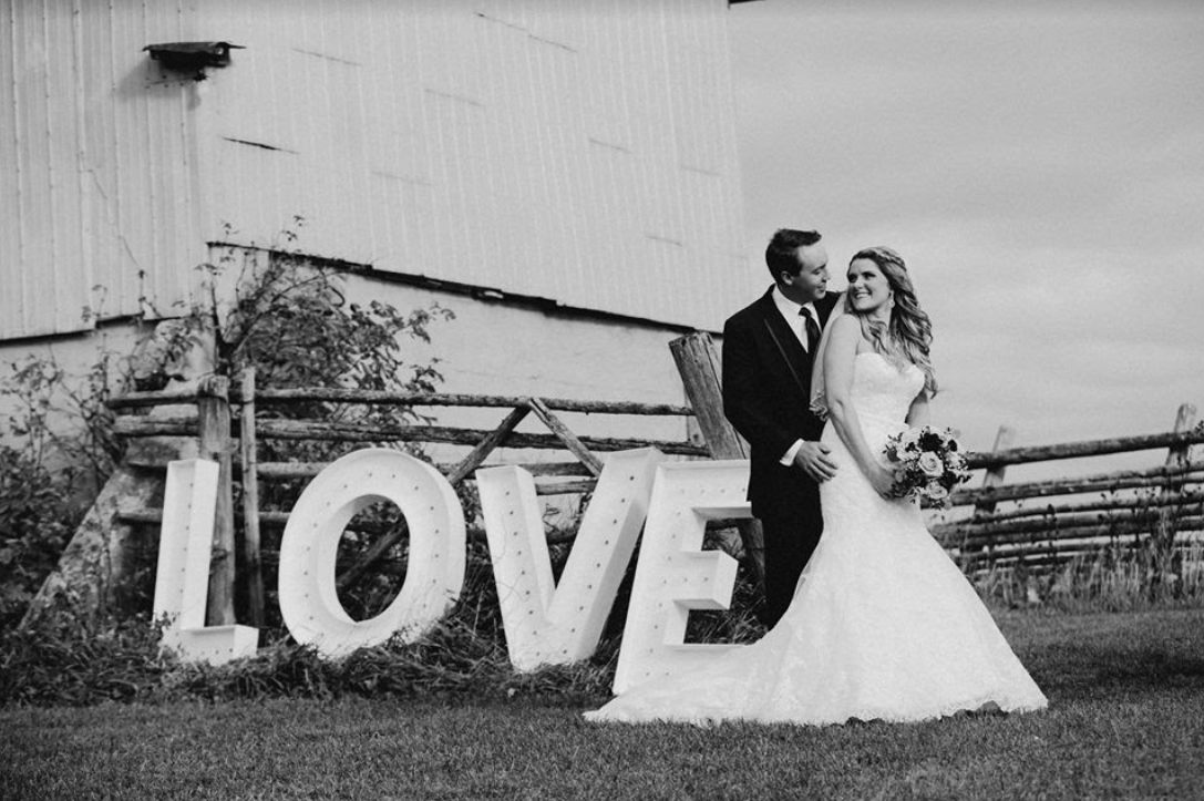 Couple standing in front of a Love Sign